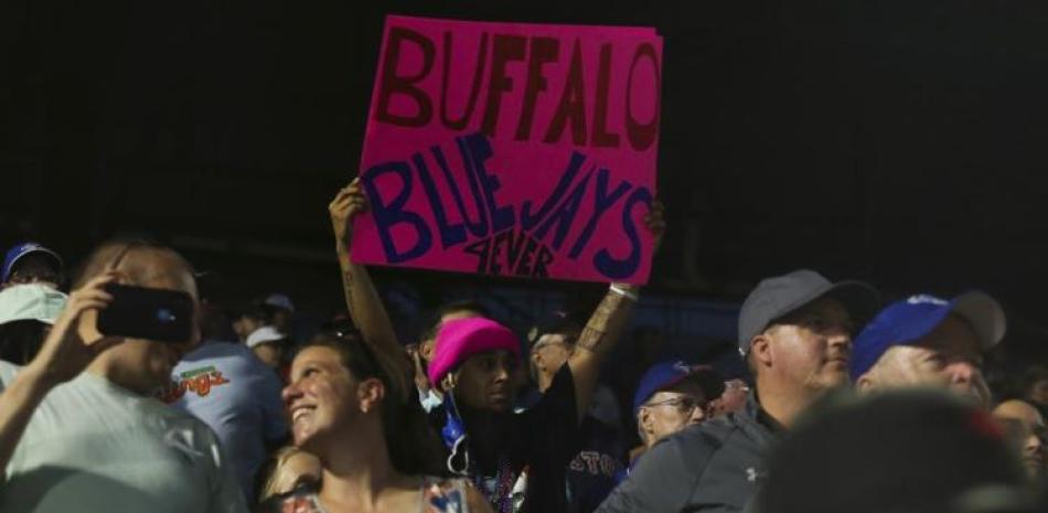 Un grupo de fanáticos muestra un cartel de apoyo a los Azulejos de Toronto, que disputaron su último duelo en Buffalo, Nueva York, su casa temporal.