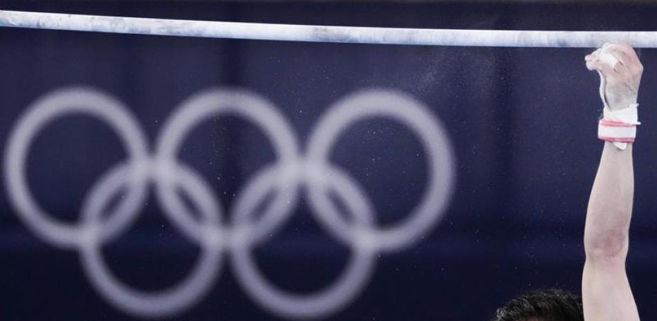 El japonés Kohei Uchimura cae de la barra horizontal durante la calificación en gimnasia artística, en los Juegos Olímpicos de Tokio, el 24 de julio de 2021, en Tokio. (AP Foto/Ashley Landis)