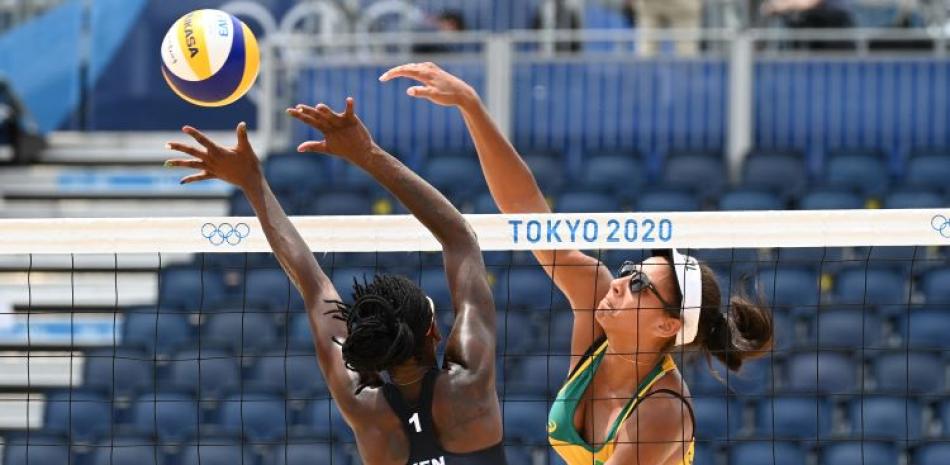 Ana Patricia Silva, de Brasil, ataca frente a la defensa de Gaudencia Makokha, de Kenia, durante el partido de voleibol de playa en los Juegos Olímpicos de Tokio 2020.