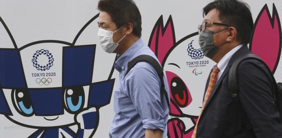 Dos personas caminan por delante de un cartel promocional de los Juegos Olímpicos, en Tokio, el 16 de junio de 2021.

Foto: AP/Koji Sasahara