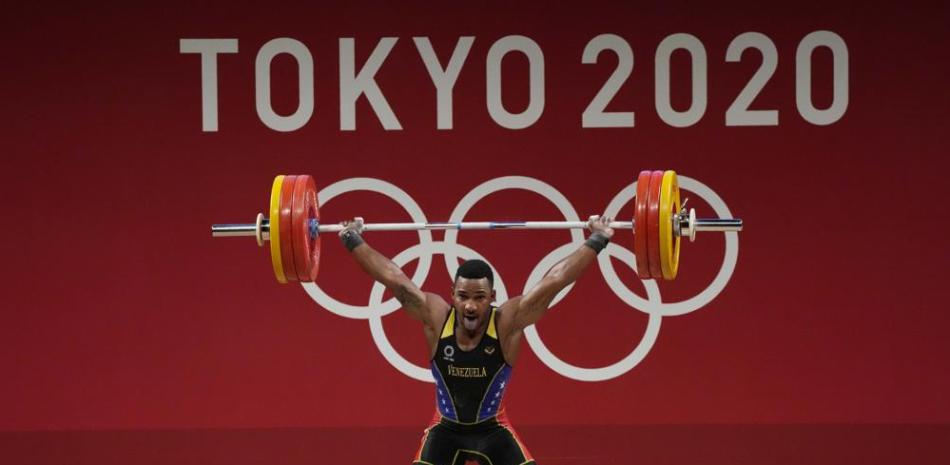 Julio Mayora, de Venezuela, aparece en acción durante las competencias de levantamiento de pesas en los Juegos Olímpicos.