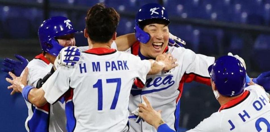 Varios peloteros de Corea festejan en el terreno de juego la victoria de su equipo ante Dominicana.
