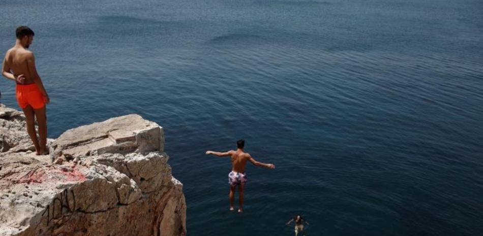 Un hombre se sumerge en el mar, en plena ola de calor, en Varkiza, cerca de Atenas, (Grecia). EFE / EPA / YANNIS KOLESIDIS