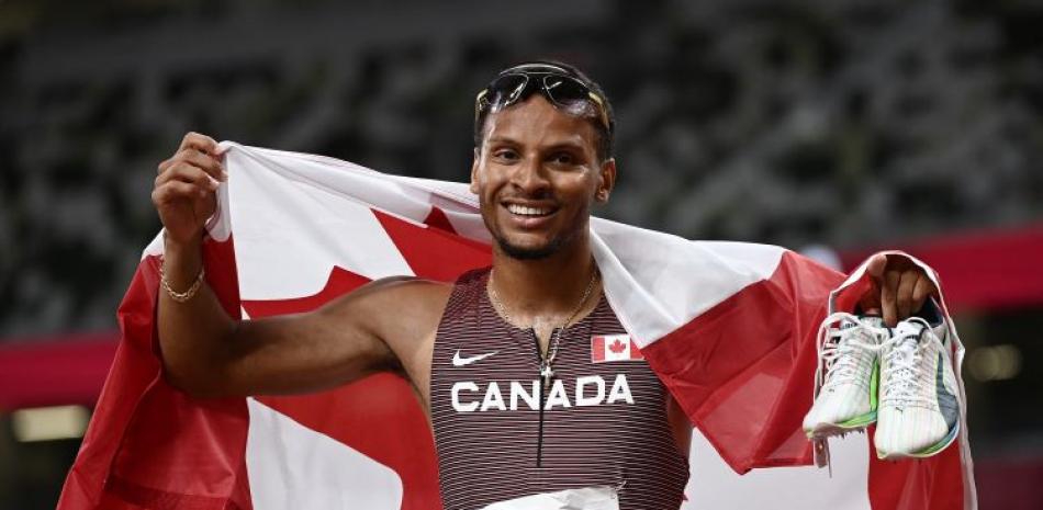 Andre De Grasse posa con la bandera de Canadá luego de ganar la prueba de los 200 metros planos en los Juegos Olímpicos de Tokio 2020.