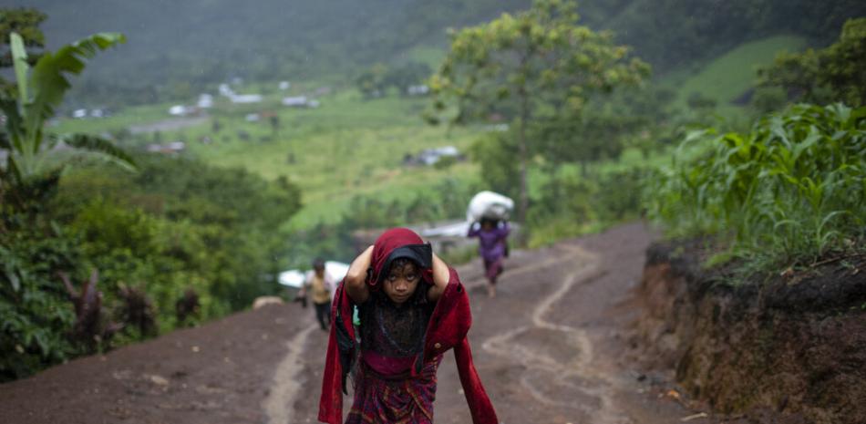 Tras intensas lluvias, una niña carga madera para cocinar en el asentamiento de Nuevo Quejá, Guatemala, el lunes 5 de julio de 2021.

Foto: AP/Rodrigo Abd