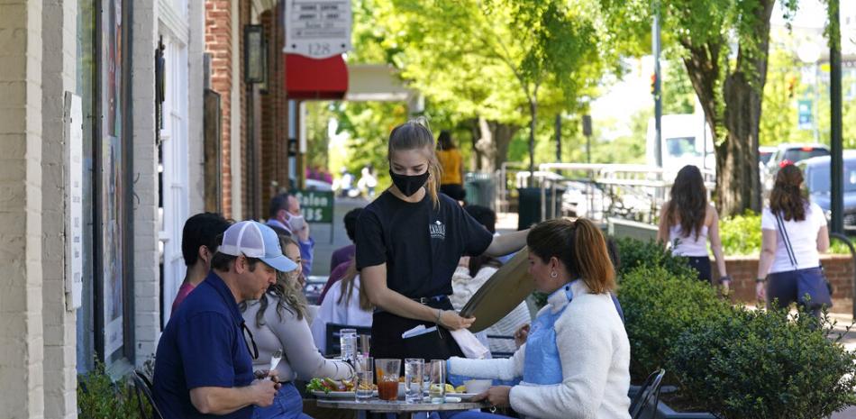 Una mesera asiste a dos personas en mesas al aire libre en un restaurante de Chapel Hill, Carolina del Norte, el 16 de abril del 2021.

Foto: AP/Gerry Broome