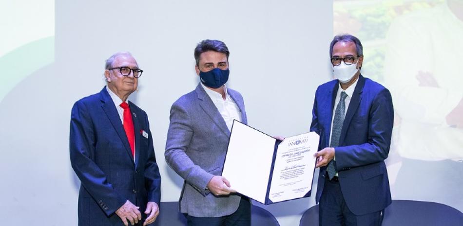 Rafael Monestina, vicepresidente ejecutivo de Supermercados Bravo, recibe su reconocimiento de Luis Sánchez Noble y José Mármol.
