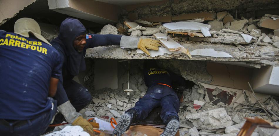 Los bomberos buscan sobrevivientes dentro de un edificio derrumbado, después del terremoto de magnitud 7.2 en Les Cayes, Haití, el domingo 15 de agosto de 2021.

Foto: AP/ Joseph Odelyn