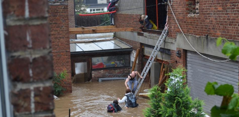 Esta fotografía tomada el 15 de julio de 2021 muestra a una familia belga a la que se ayudó a ponerse a salvo después de que su casa fue envuelta por las inundaciones del río Vesdre en Trooz. 

Fotos: Charles Clessens/ AFP