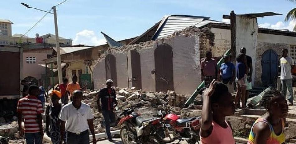 Personas a los alrededores de edificaciones destruidas. / AFP