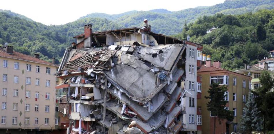 Un hombre observa el sábado 14 de agosto de 2021 un edificio de aparatmentos destruido tras las fuertes inundaciones y deslaves en la localidad de Bozkurt, provincia de Kastamonu, en Turquía. (AP Foto).