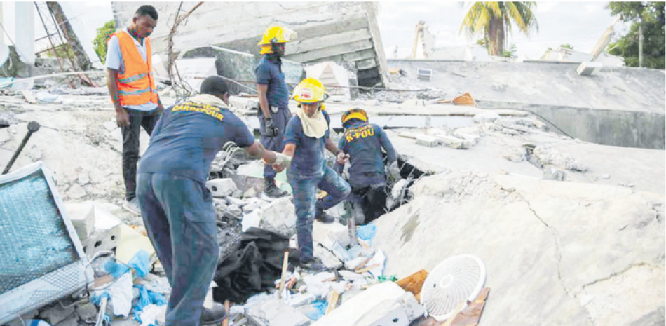 Bomberos haitianos buscan a sobrevivientes dentro de un edificio colapsado, luego del terremoto de 7.2 de escala Richner que azotó el Este de Haití. AP