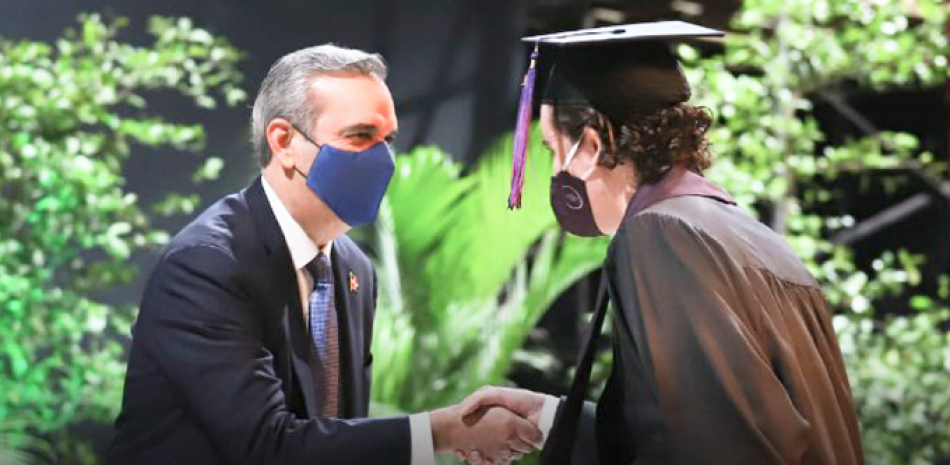 El presidente Luis Abinader felicita a uno de los graduandos.