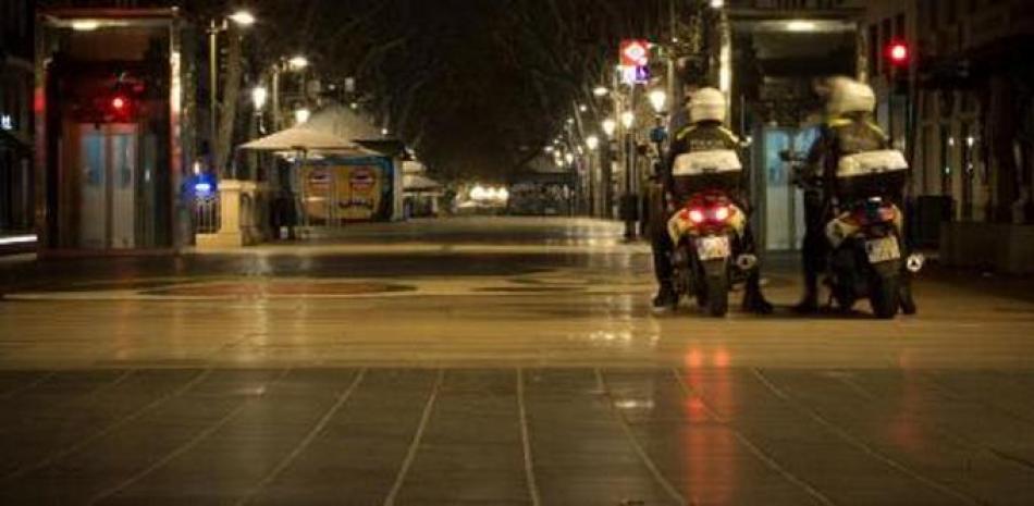 Dos agentes de la Guàrdia Urbana patrullan por la Rambla de Barcelona una noche con toque de queda. Getty Images
