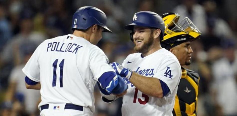 Max Muncy (centro) celebra un jonrón de tres carreras con su compañero de los Dodgers AJ Pollock en el cuarto inning del juego contra los Piratas.