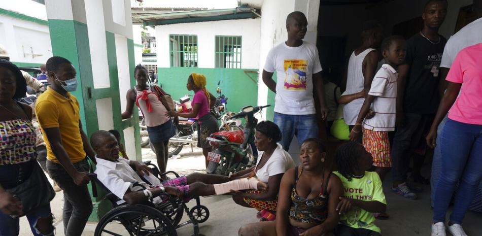 Personas heridas en un accidente de auto, sentadas a la derecha, esperan junto a otros heridos durante el sismo, para una radiografía en el Hospital General de Les Cayes, Haití, el 18 de agosto de 2021.

Foto: AP/Fernando Llano
