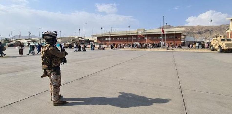Soldados en la pista esperando que los pasajeros que intentan huir de Afganistán, suban a un avión militar italiano en el aeropuerto de Kabul para volar a Roma. AFP/