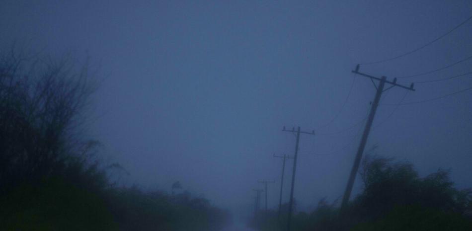 Un poste que sostiene cables de energía eléctrica se dobla a causa de los vientos causados por el huracán Ida en un camino que conduce a Batabanó, en la provincia de Mayabeque, en Cuba, el vienres 27 de agosto de 2021.

Foto: AP/Ramon Espinosa