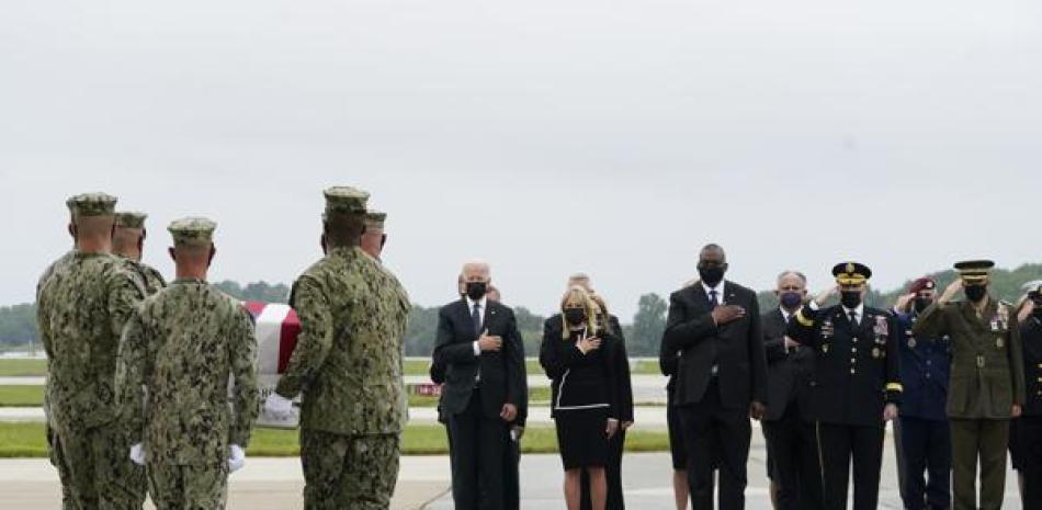 El presidente Joe Biden observa a mientras elementos de la Marina cargan el féretro con los restos del cabo de la marina Maxton W. Soviak, de 22 años, el domingo 29 de agosto de 2021, en la base aérea Dover, en Delaware. (AP Foto/Manuel Balce Ceneta)