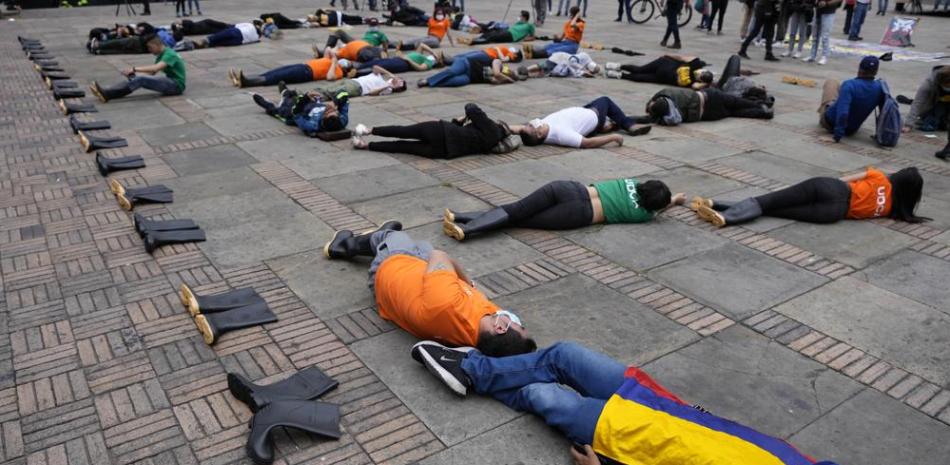 Manifestantes yacen en el suelo en la plaza Bolívar para protestar por la matanza de civiles durante el conflicto interno de Colombia, supuestamente a manos de las fuerzas de seguridad, en Bogotá. Foto AP