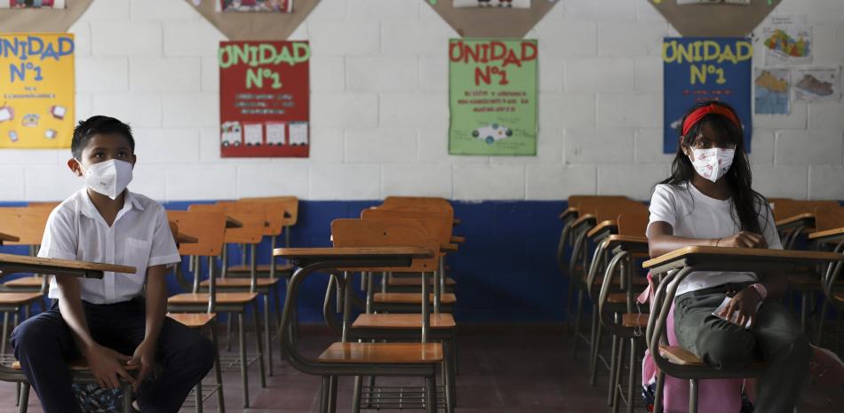 Estudiantes mantienen distancia social el primer día de regreso a la escuela presencial, en Antiguo Cuzcatlan, El Salvador, el martes 6 de abril de 2021.

Foto: AP/Salvador Melendez