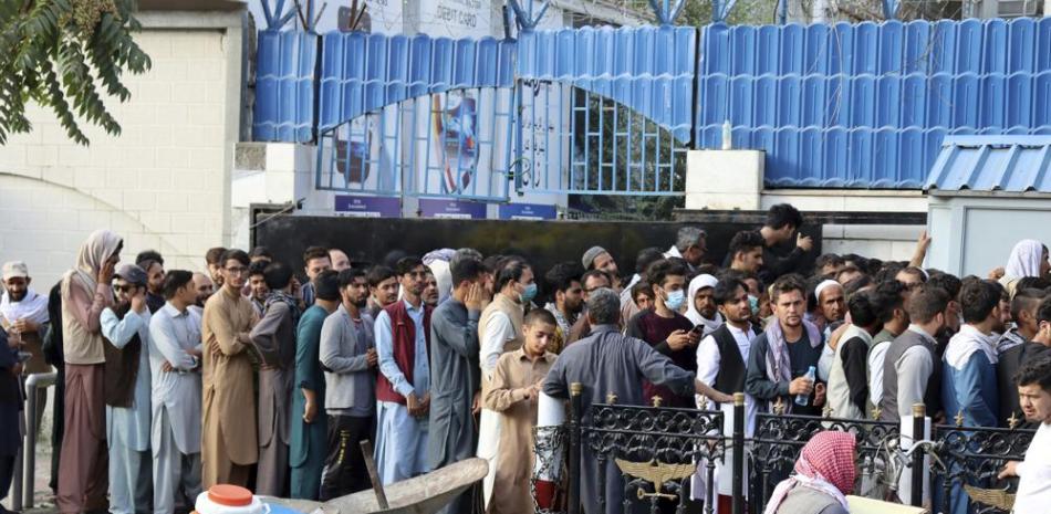 Afganos hacen fila durante horas en un intento para retirar dinero en un banco en Kabul, Afganistán, el lunes 30 de agosto de 2021. Los talibanes limitaron los retiros semanales a un equivalente a 200 dólares. (AP Foto/Khwaja Tawfiq Sediqi)