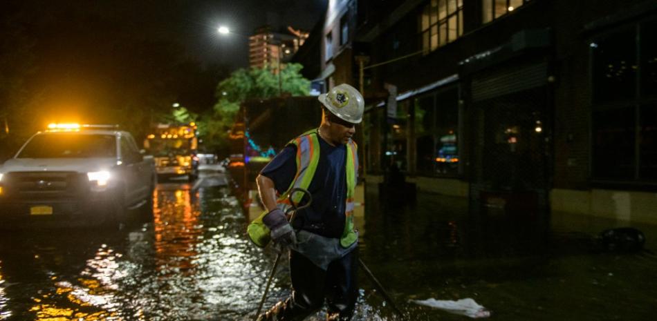 Un trabajador desbloquea los desagües en una calle afectada por las inundaciones en Brooklyn, Nueva York, a principios del 2 de septiembre de 2021, cuando las inundaciones repentinas y las lluvias récord traídas por los restos de la tormenta Ida barrieron el área.

Foto: Ed Jones/ AFP