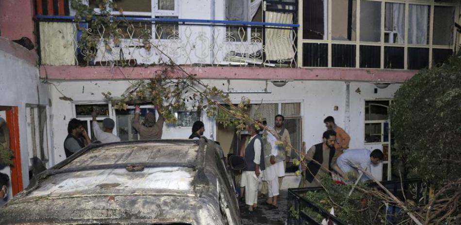 ARCHIVO - En esta fotografía del domingo 29 de agosto de 2021, algunas personas inspeccionan los daños en la casa de la familia Ahmadi después de un ataque con drones de Estados Unidos en Kabul, Afganistán. (AP Foto/Khwaja Tawfiq Sediqi, Archivo)