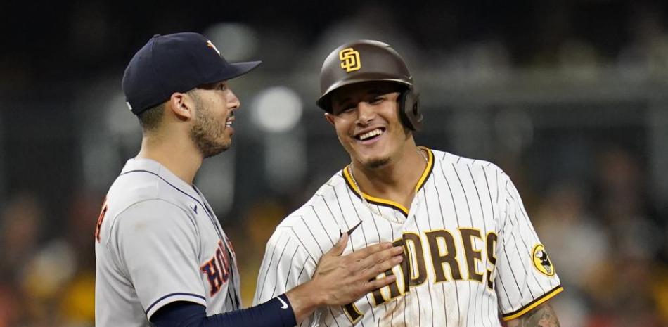 El campocorto de los Astros de Houston Carlos Correa (izquierda) bromea con Manny Machado, de los Padres de San Diego, en la segunda base en el séptimo inning del juego de la MLB que enfrentó a ambos equipos.