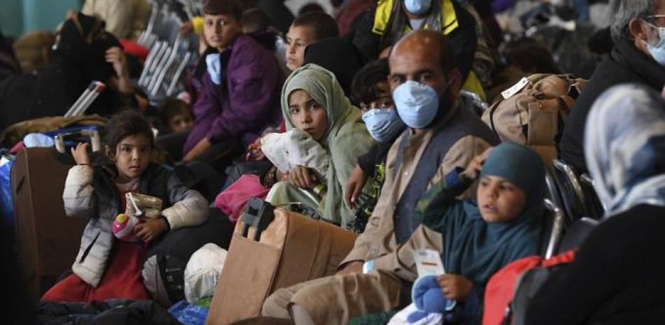 Refugiados afganos se encuentran en el Hangar 5 de la base aérea estadounidense de Ramstein, Alemania, 8 de septiembre de 2021. (Olivier Douliery/Pool Photo via AP)