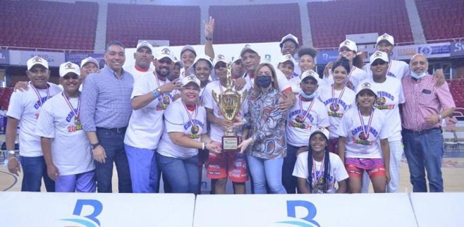 El equipo de las Murallas de San Lázaro recibe al Copa Don Máximo Bernard-Banreservas, de parte de la presidente del comité organizador de la Liga Nacional de Baloncesto Femenino, Gloria Reyes.