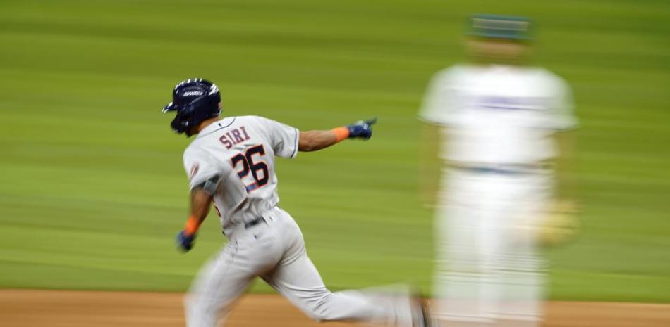 El jugador de los Astros de Houston José Siri (26) celebra su jonrón solitario mientras recorre las bases, bajo la mirada del primera base de los Rangers Nathaniel Lowe.