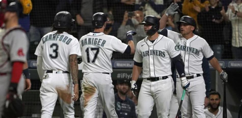 El jugador de los Marineros de Seattle Mitch Haniger (17) recibe la felicitación de sus compañeros tras disparar un jonrón de tres carreras contra los Medias Rojas.