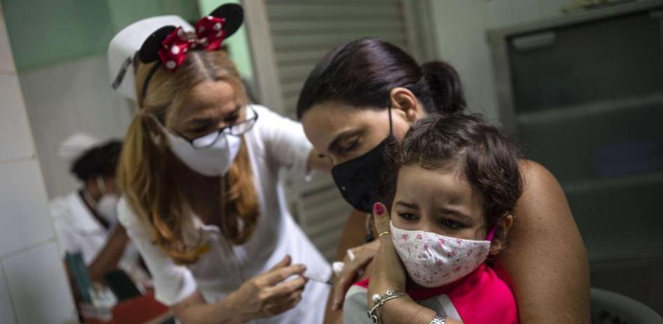 Una madre sostiene a su hija a la que se le inyecta una dosis de la vacuna Soberana-02 para el COVID-19 en La Habana, Cuba, el jueves 16 de septiembre de 2021. (AP Foto/Ramón Espinosa)