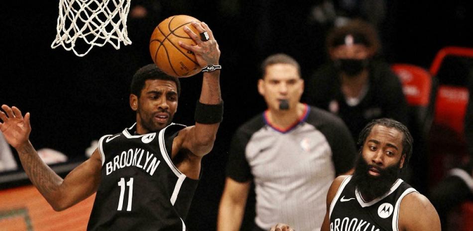 Kyrie Irving, de los Nets, toma un rebote ante la mirada de James Harden, a la derecha, en un partido de la pasada temporada de la NBA.