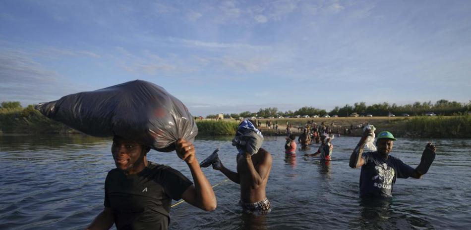 Migrantes, muchos de Haití, cruzan el Río Bravo mientras abandonan Del Río, Texas, para regresar a Ciudad Acuña, México, el miércoles 22 de septiembre de 2021 temprano, algunos para evitar una posible deportación de EEUU otros a conseguir suministros. (AP Foto/Fernando Llano)