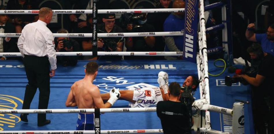 Callum Smith, a la izquierda, observa al dominicano Lenin Castillo luego de noquearlo durante su pelea de peso ligero en el estadio Tottenham Hotspur Stadium en Londres.