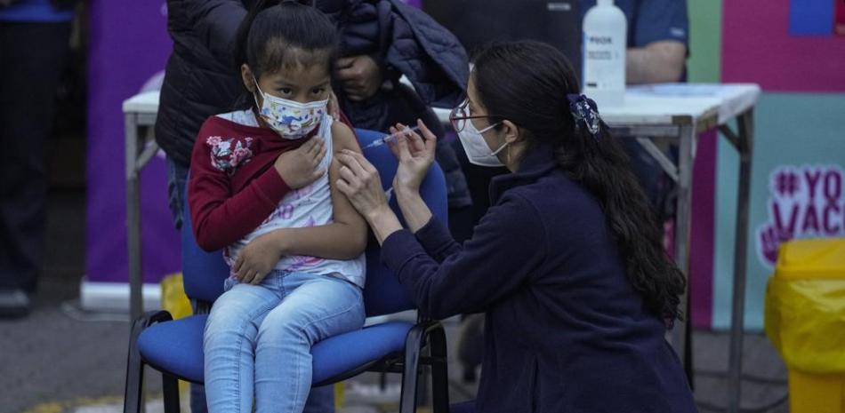 Un trabajador de la salud inocula a un niño contra el COVID-19 en la escuela Providencia en Santiago, Chile, el lunes 27 de septiembre de 2021, durante el inicio de la vacunación en escuelas para niños de 6 a 11 años. (AP Foto/Esteban Felix)
