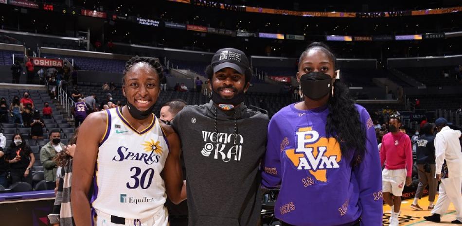 Nneka Ogwumike, de las Sparks de Los Angeles, Kyrie Irving, de los Nets de Brooklyn y Chiney Ogwumike, de las Sparks posan en un partido de la WNBA.
