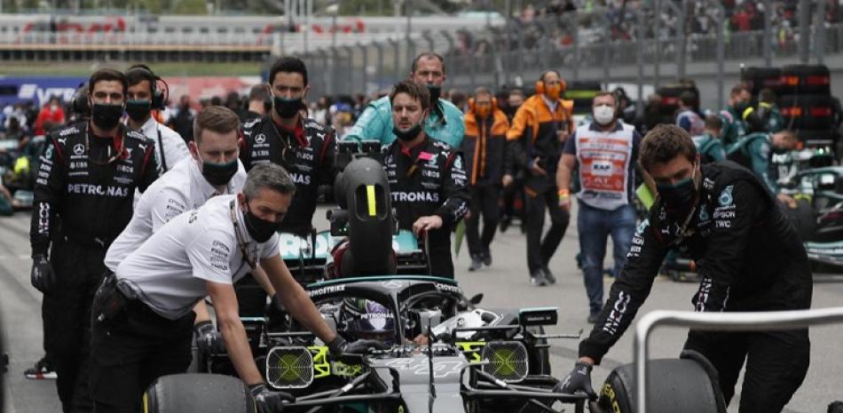 Mecánicos empujan el Mercedes de Lewis Hamilton en la parrilla previo al Gran Premio de Rusia en el circuito de Sochi, el domingo 26 de septiembre de 2021.