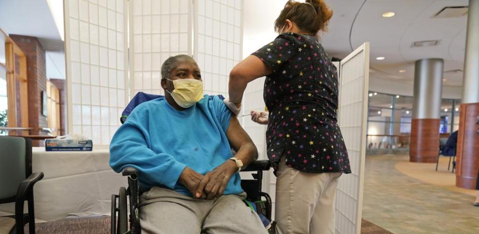 Edward Williams, de 62 años, interno de la residencia Hebrew Home en Riverdale, recibe una dosis de refuerzo de la vacuna contra el COVID-19 en Nueva York, el lunes 27 de septiembre de 2021. (AP Foto/Seth Wenig)