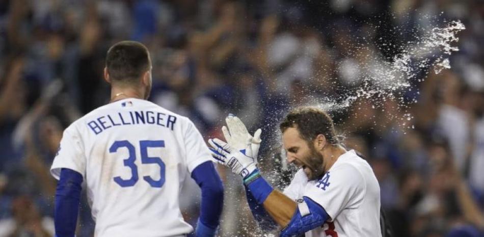 Chris Taylor, de los Dodgers, festeja con Cody Bellinger, a quien empujó con un jonrón en la novena entrada del juego de comodines ante los Cardenales de San Luis.