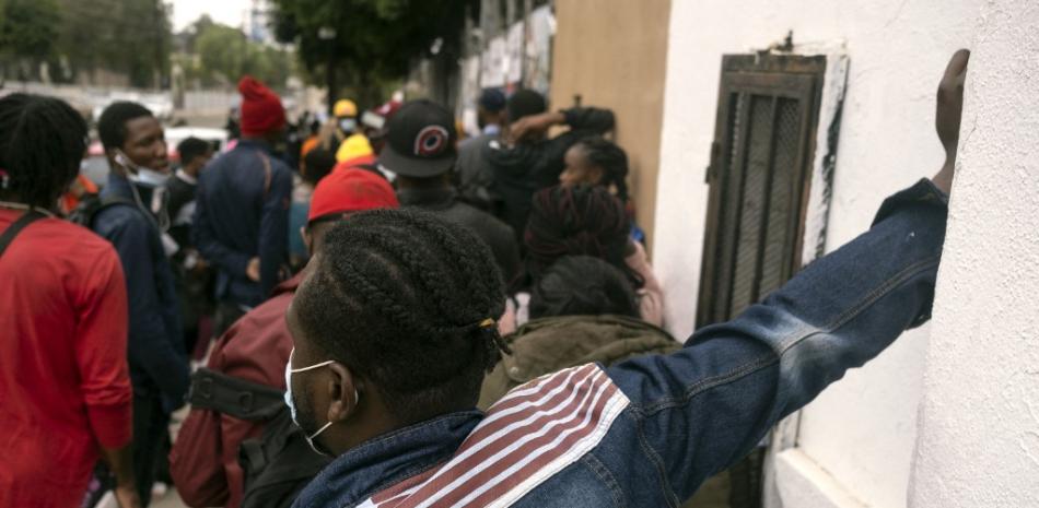 Migrantes haitianos hacen cola para registrarse en la Comisión Nacional de Refugiados (COMAR) en Tijuana, estado de Baja California, México, el 6 de octubre de 2021, en México. 

Foto: Guillermo Arias/ AFP