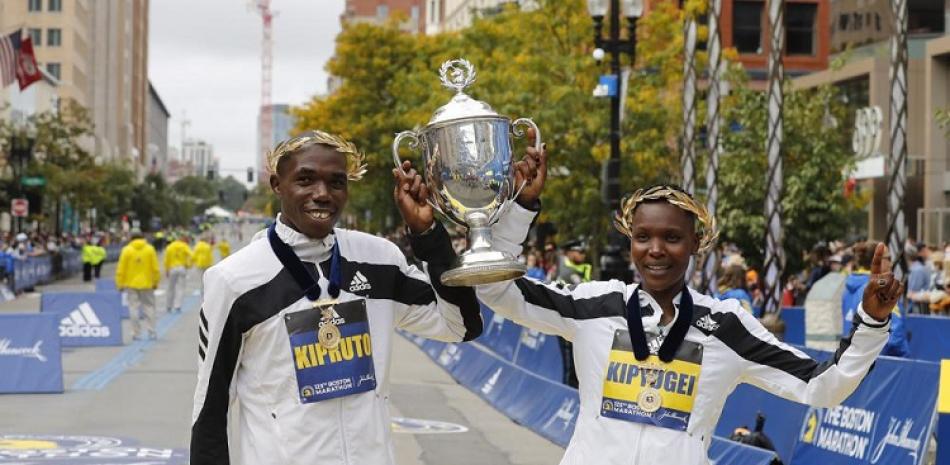 Los kenianos Benson Kipruto (izquierda) y Diana Kipyogei festejan tras ganar el maratón de Boston.