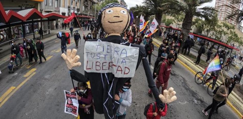 Indígenas mapuche sostienen un muñeco que dice “Tierra, justicia, libertad” en el centro de Santiago, el 10 de octubre de 2021, en medio de la conmemoración del Día de la Raza. MARTIN BERNETTI / AFP