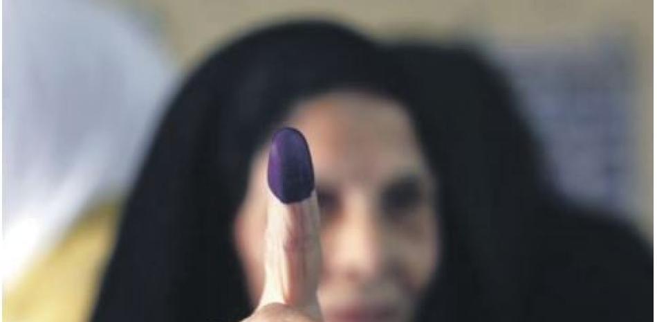 Una mujer iraquí muestra su dedo tintado tras votar en un centro electoral en las elecciones parlamentarias, ayer domingo. AP