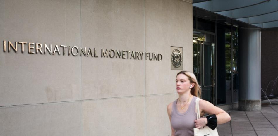 Una mujer pasa por la sede del Fondo Monetario Internacional en Washington, DC el 7 de octubre de 2021. Las reuniones anuales se llevarán a cabo del 11 al 17 de octubre de 2021. MANDEL NGAN / AFP