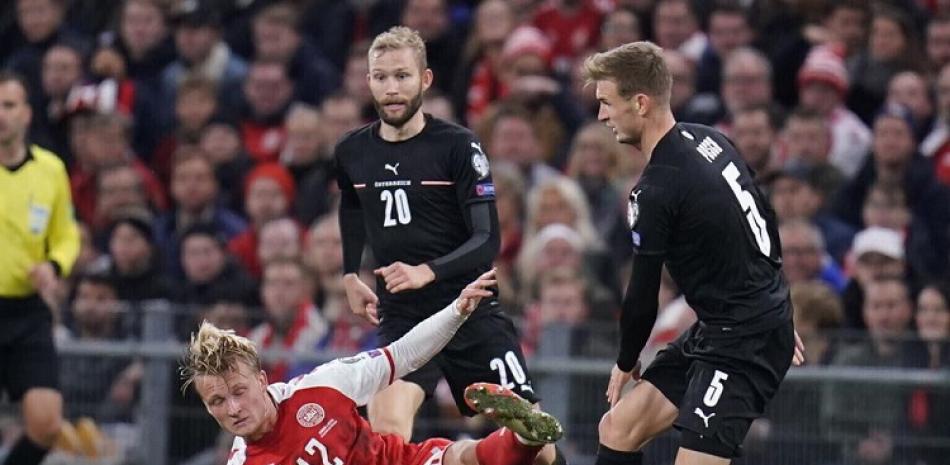 El danés Kasper Dolberg (izquierda) y los austriacos Martin Hinteregger (derecha) y Konrad Laimer pugnan un balón en el partido por las eliminatorias del Mundial.