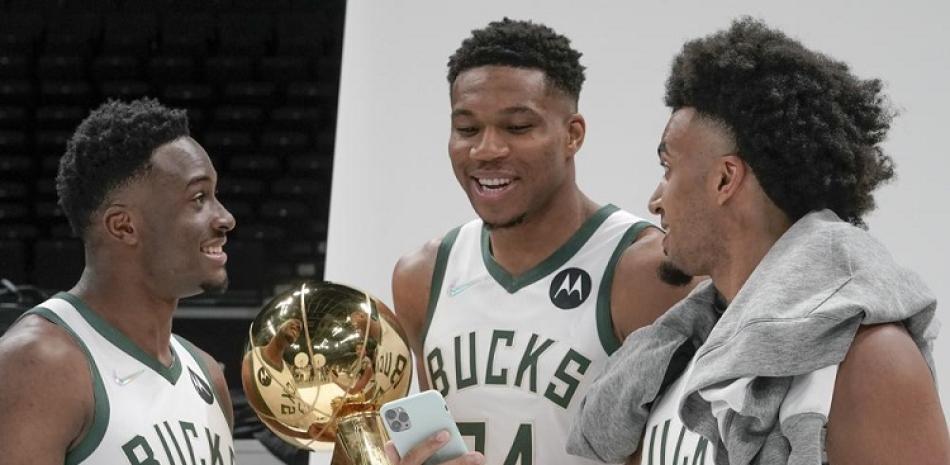 Thanasis Antetokounmpo, Giannis Antetokounmpo y Jordan Nwora de los Bucks de Milwaukee posan con el trofeo durante el día de medios de la NBA en Milwaukee.