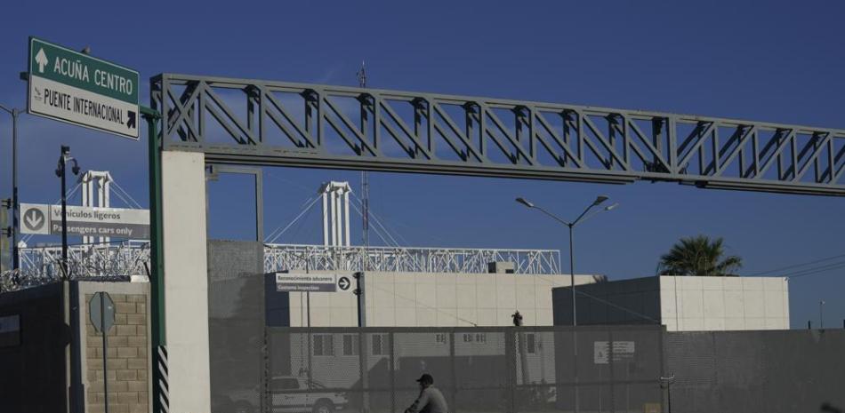 Un hombre en bicicleta frente a la entrada cerrada de un puente fronterizo internacional que conecta a las ciudades de Del Río, Texas, y Ciudad Acuña, México, el viernes 24 de septiembre de 2021. (AP Foto/Fernando Llano)